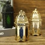 Set of three engraved brass candle holders with green and red glass panels on white background