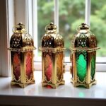 Engraved brass candle holders with jewel-tone glass on windowsill featuring ornate Islamic-inspired patterns