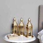 Engraved brass candle holders with ornate patterns on round bedside table next to book and pumpkin