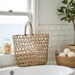 Angled view of handwoven straw mesh beach bag showing knotted pattern depth and shape
