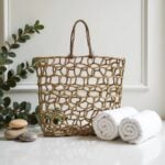 Twisted straw rope handles on natural beige mesh beach bag with hand-knotted detail