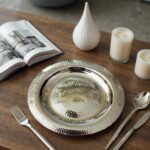 Round silver decorative tray side profile showing raised rolled rim and shallow concave basin