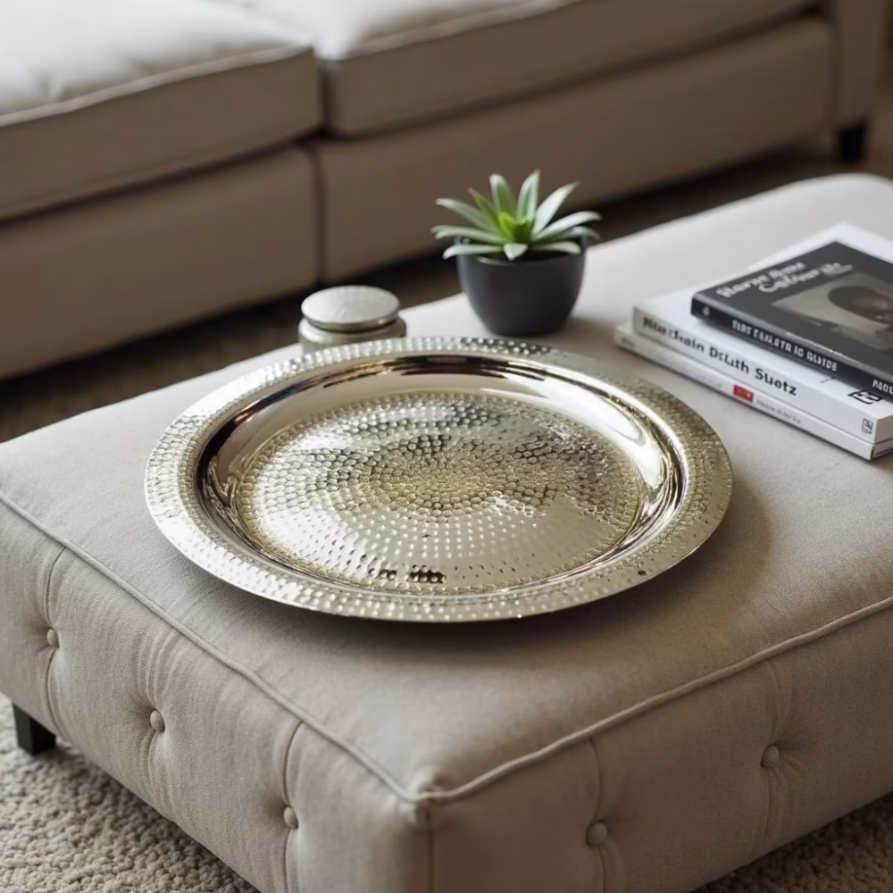 Handcrafted silver decorative tray displayed on ottoman in living room setting