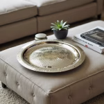 Handcrafted silver decorative tray displayed on ottoman in living room setting