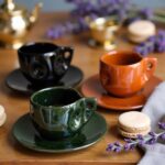 Artisan Moroccan ceramic coffee cups on wooden tray with croissants in modern kitchen setting