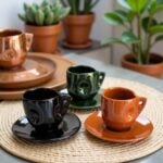 Three Moroccan ceramic coffee cups with saucers on woven placemat featuring hand-glazed finish in rich tones