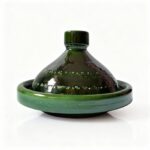 Green ceramic tagine pot with conical lid and flat base, handcrafted Moroccan cookware on white background