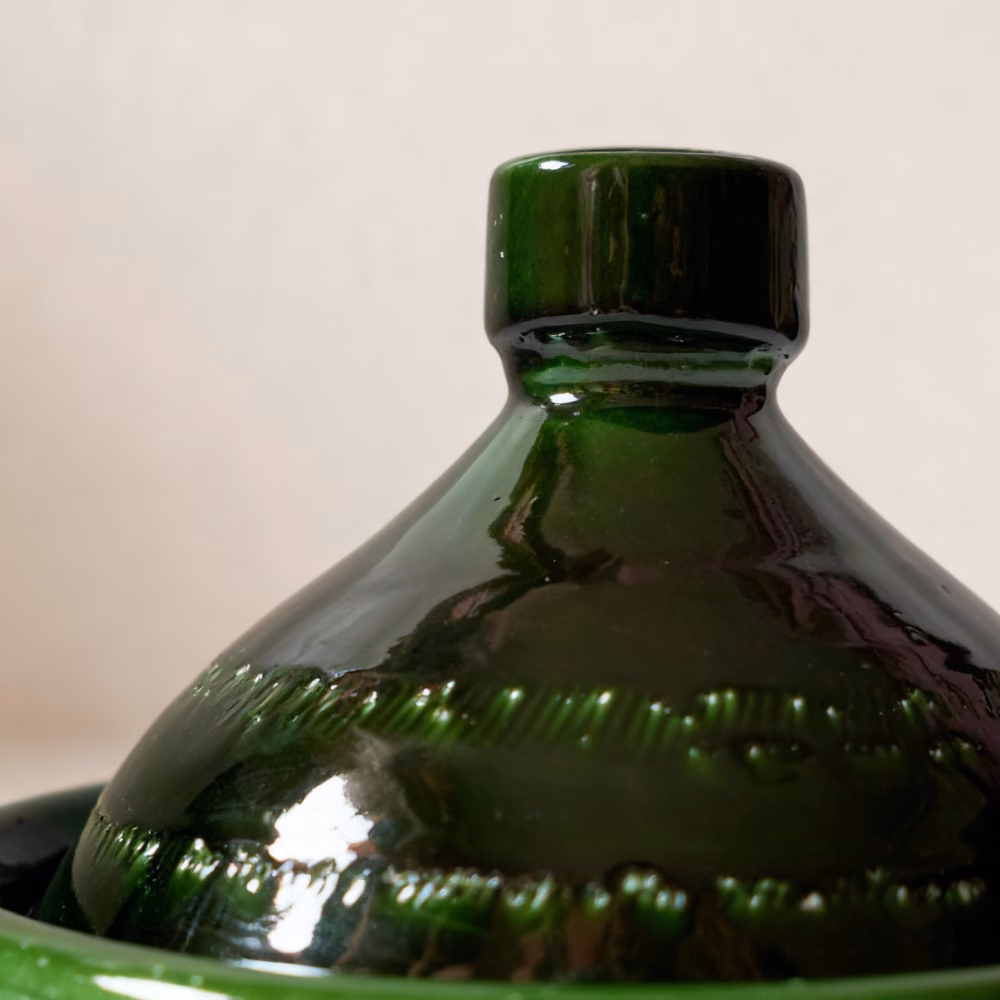 Close-up detail of handmade green tagine pot showing traditional Moroccan craftsmanship