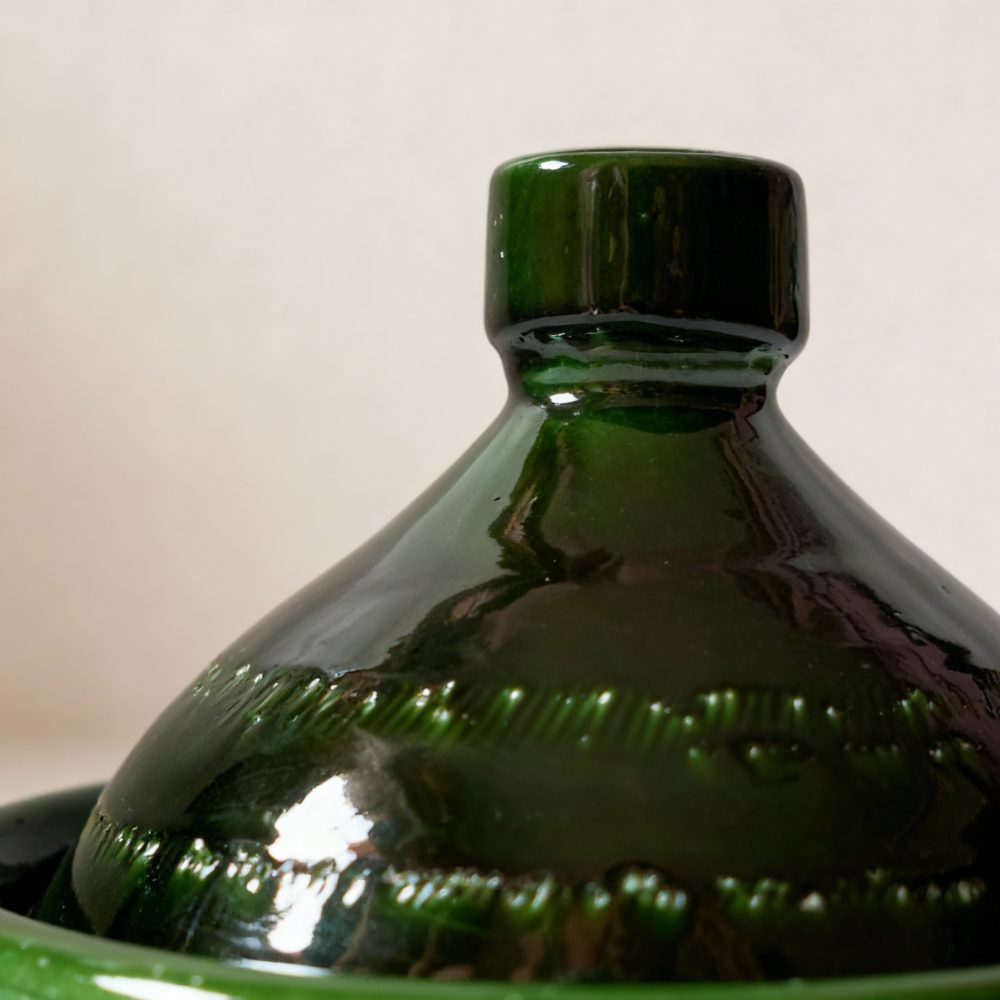 Close-up detail of handmade green tagine pot showing traditional Moroccan craftsmanship
