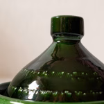 Close-up detail of handmade green tagine pot showing traditional Moroccan craftsmanship