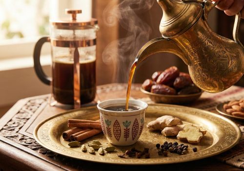 Moroccan spiced coffee with cinnamon sticks, cardamom pods, cloves, and ginger served in a traditional ceramic cup with dates and nuts