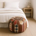 Leather round ottoman 21" patchwork pouf placed at foot of bed in minimalist bedroom decor
