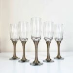 Set of 6 silver champagne flutes with Moroccan filigree wire-wrapped metal stems on white background
