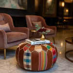 Luxurious interior featuring a round leather pouf ottoman used as a boho coffee table between velvet chairs.
