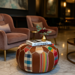 Luxurious interior featuring a round leather pouf ottoman used as a boho coffee table between velvet chairs.