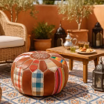 Outdoor Moroccan terrace setup with a round leather pouf ottoman, silver teapot, and traditional mint tea.