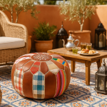 Outdoor Moroccan terrace setup with a round leather pouf ottoman, silver teapot, and traditional mint tea.