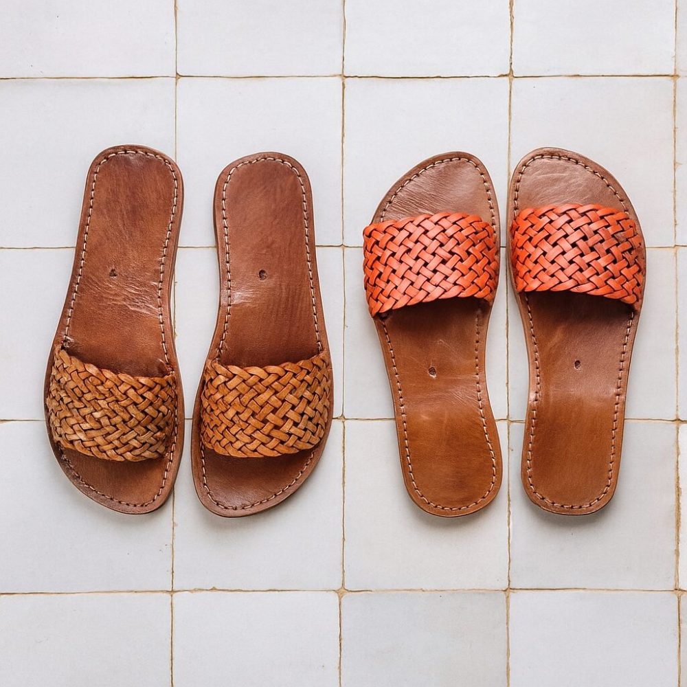 Close-up comparison of light-brown and orange Leather Slides on zellige floor tiles.