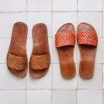 Close-up comparison of light-brown and orange Leather Slides on zellige floor tiles.
