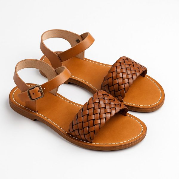 Light tan braided leather sandals on white studio background with brass buckle and hand-stitched sole.