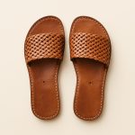Studio shot of light-brown woven Leather Slides highlighting artisanal stitching.