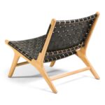 Rear angled view of black leather lounge chair showing basketweave pattern and teak frame