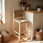 Natural handwoven bar chair with palm fiber seat in cozy kitchen corner surrounded by plants and baskets
