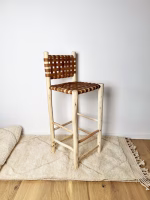 Pair-of-artisan-crafted-Moroccan-leather-bar-stools-on-neutral-rug