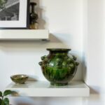 Artisan ceramic vase 30cm featuring green glaze and raised studs displayed on white minimalist shelf