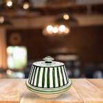Handcrafted Moroccan tagine with green and white vertical stripes and traditional conical lid