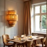 Elegant tiered handwoven raffia wall sconce with warm glow above dining table in bright white interior