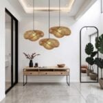 Cluster of three handwoven rattan pendant lamps in entryway above console table with modern mirror