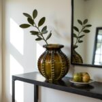 Traditional ceramic vase 30cm holding eucalyptus branch on black console table with green fruit styling