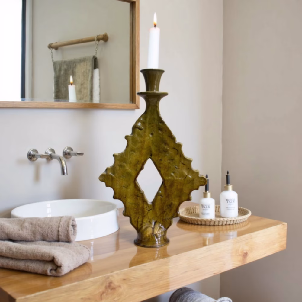Artisanal ochre candle holder on wooden bathroom counter