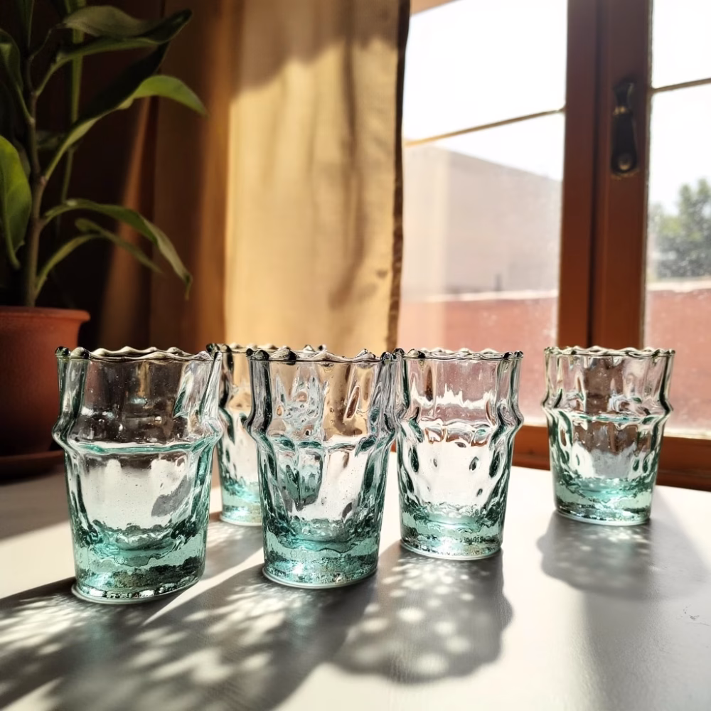Blue-green glasses of tea catching afternoon sunlight