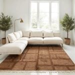 Modern Moroccan wool rug in tan with grid pattern under sectional sofa in bright minimalist living room