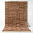 Handwoven Moroccan wool rug with textured grid pattern in natural brown tones and fringe detail