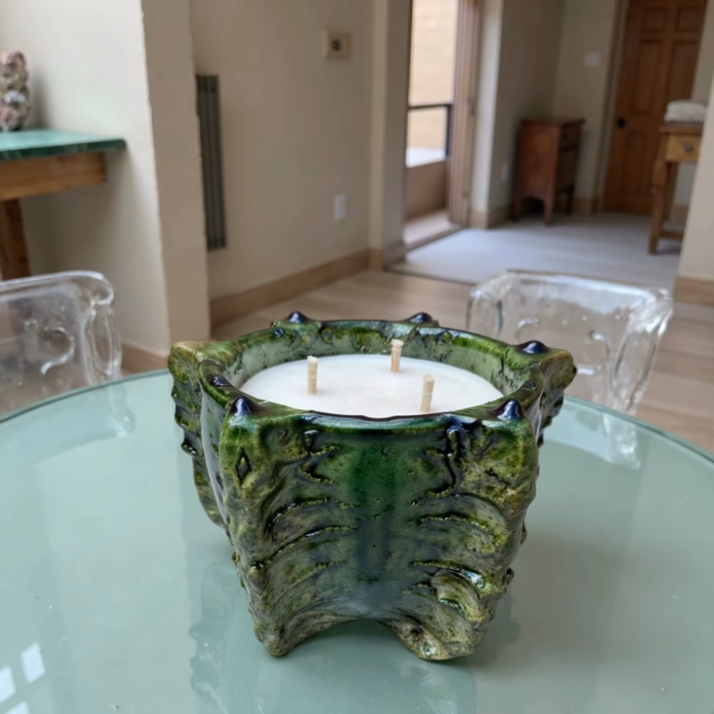 Close-up of leaf-patterned ceramic candle on glass table