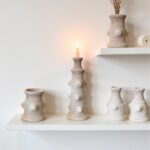 Collection of white ceramic candlestick towers in varying heights, sculptural pottery design with organic bumpy texture