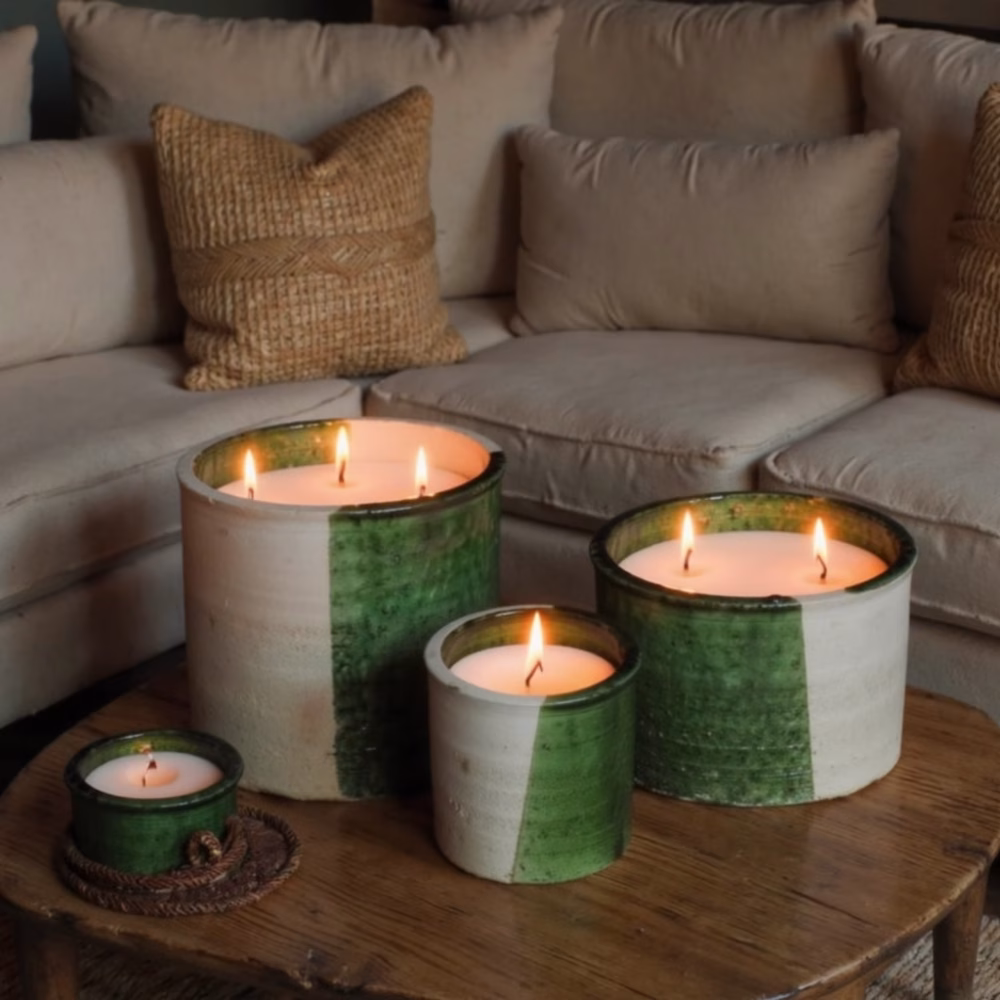 Collection of lit Moroccan ceramic candles on wooden table