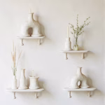 Collection of white Moroccan arch candleholders on floating shelves