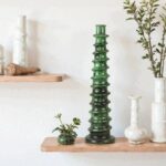 Tall Tamegroute green ceramic candle holder with textured rings displayed on natural wood shelf