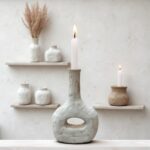 Tamegroute ceramic candle holder on white shelf, rustic gray pottery with ambient lighting design