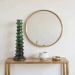 Handcrafted green ceramic candle holder with glossy glaze on bathroom vanity with mirror