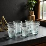 Set of six recycled aqua Beldi white geometric tea glasses with white hand-painted Moroccan motifs on dark surface