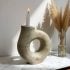 Handcrafted ceramic candle holder with organic ring shape, speckled texture, white taper candle, modern minimalist decor