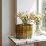 Light brown glazed planter with ferns on windowsill