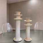 Minimalist white ceramic candleholder set on glass table