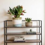 Handcrafted ceramic indoor planters set displayed on industrial metal shelf with books