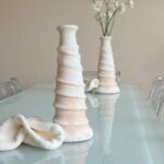 White Tamegroute ceramic candle holder set, tall spiral tower with smaller vases on glass dining table